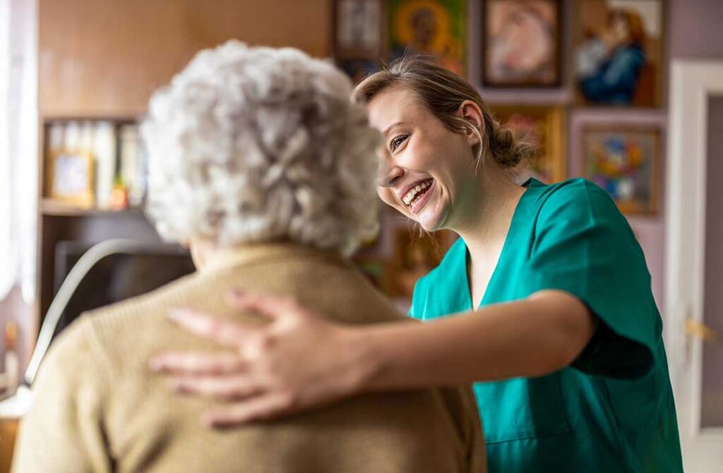 Older adult and family member reviewing home care and assisted living expenses at a kitchen table.