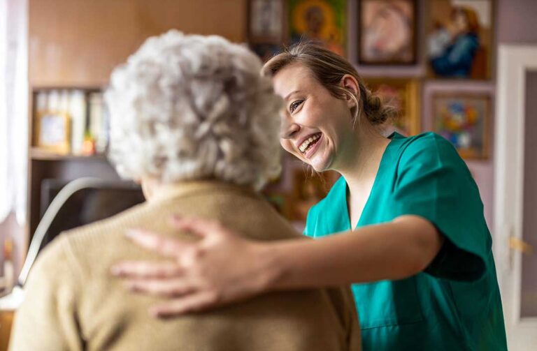 Older adult and family member reviewing home care and assisted living expenses at a kitchen table.